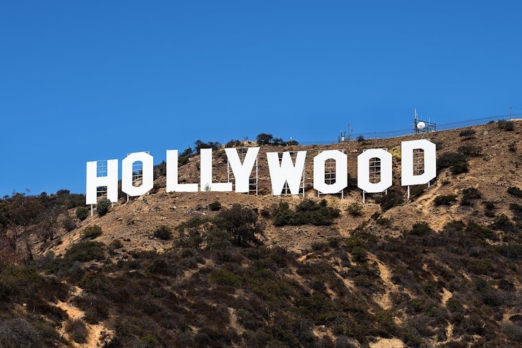 Daring Promotional Stunt: Man Waves Cryptocurrency Flag Atop Hollywood Sign in Los Angeles
