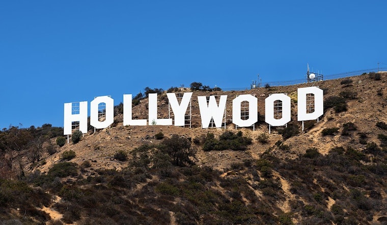 Daring Promotional Stunt: Man Waves Cryptocurrency Flag Atop Hollywood Sign in Los Angeles