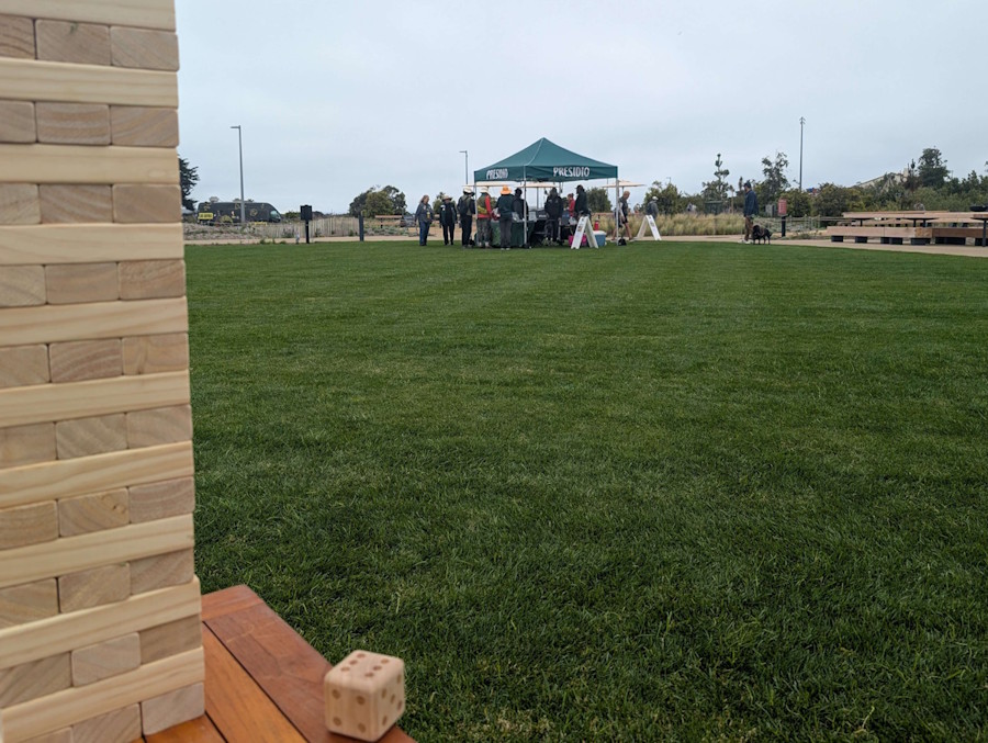 Giant Jenga game in progress with information tent visible in background