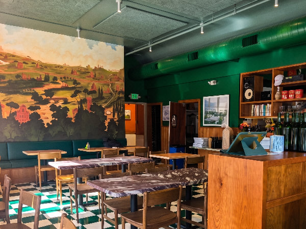 Interior of Rose Pizzeria SF showing checkered floors, mural, and dining room