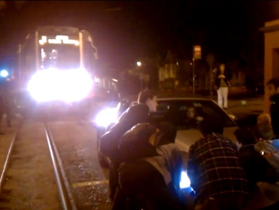 Muni Riders Lift Car Off Duboce Tracks